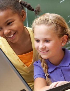 two-little-girls-in-classroom-looking-at-computer
